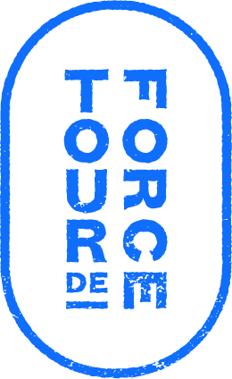 Blue text reading "TOUR DE TOUR" arranged vertically inside a blue oval outline on a black background. The letters have a bold, blocky, and somewhat distressed appearance.