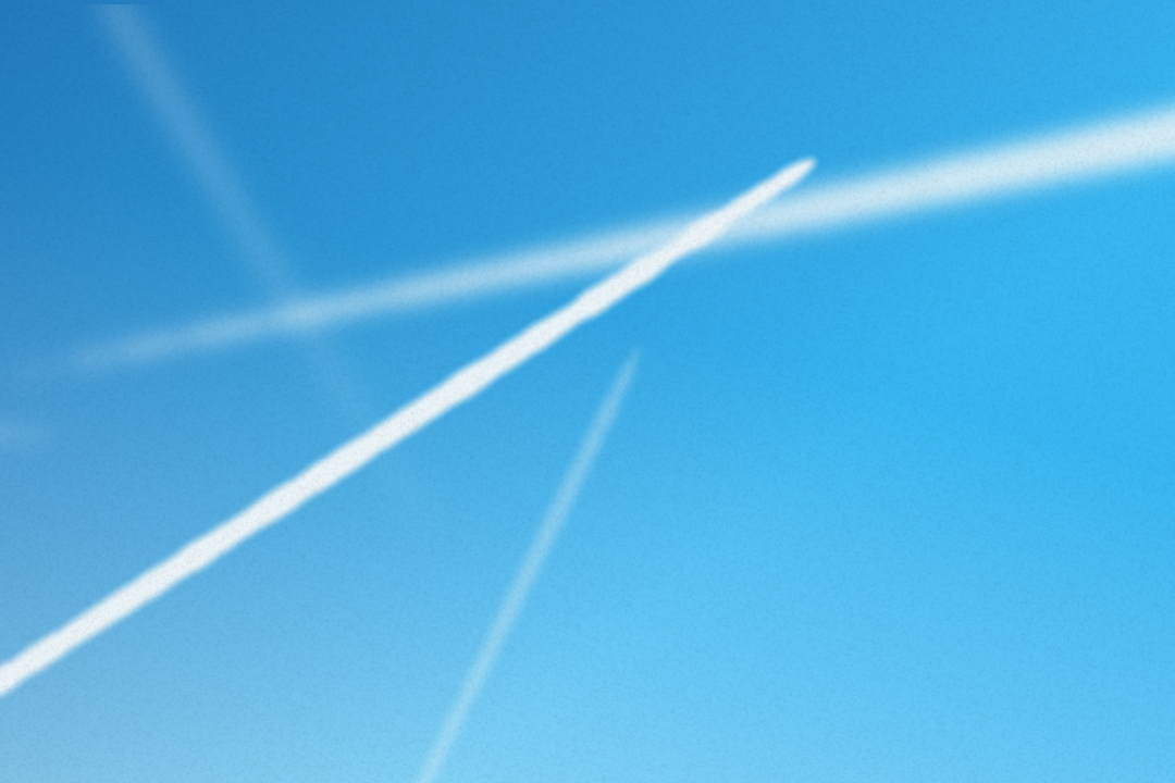 A clear blue sky crisscrossed by multiple white contrails, indicating the recent passage of several aircraft. The contrails stretch diagonally and horizontally across the image, gradually fading into the distance. No other objects are visible.