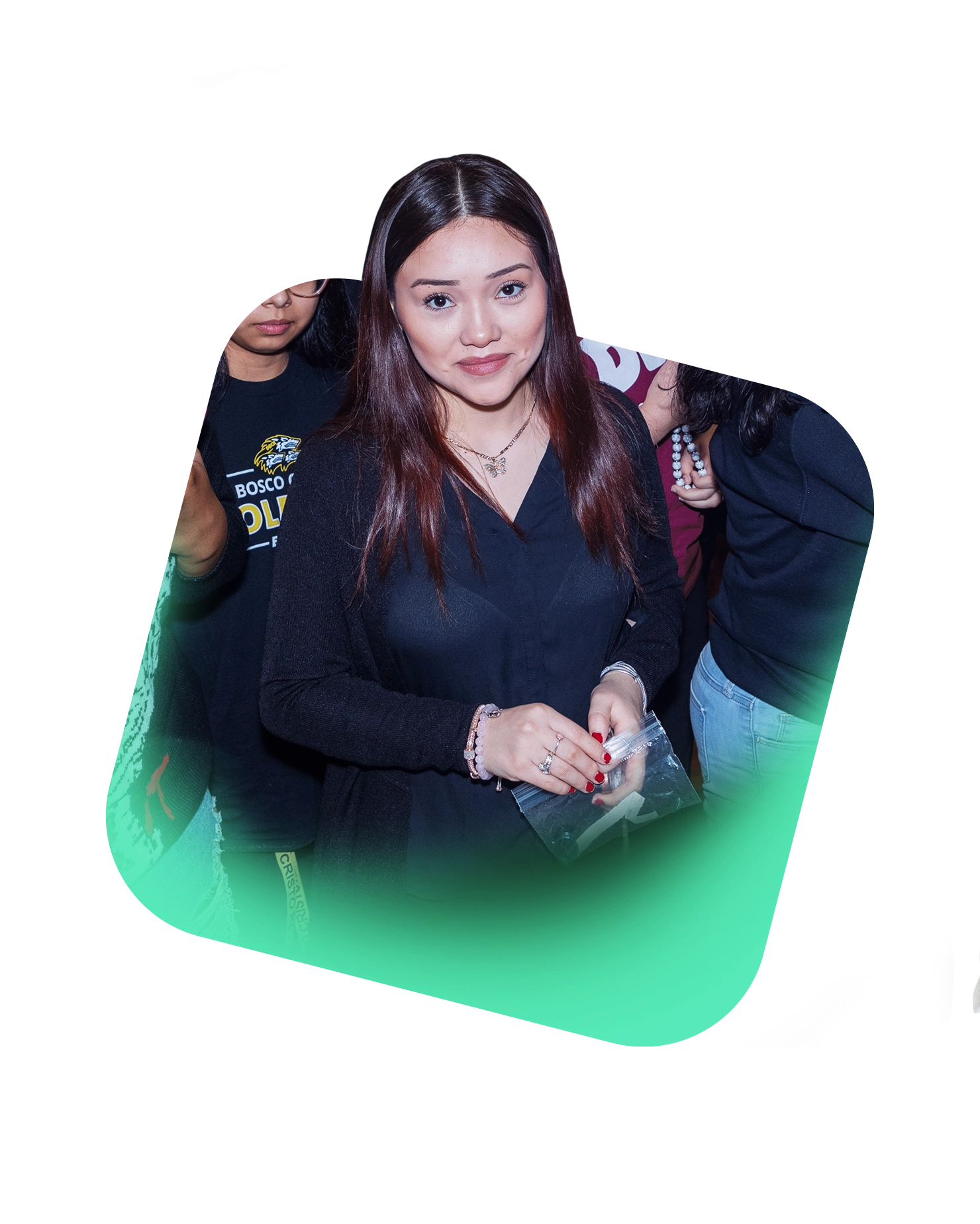 A woman with long brown hair, wearing a black top and holding a small item, stands indoors and smiles at the camera during a PATH global awareness campaign. Other people are partially visible behind her.